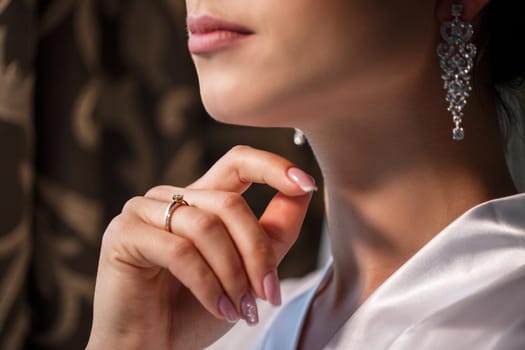 Gentle female hands of the bride with a gold wedding ring on the ring finger