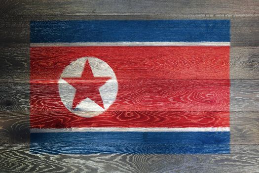 A North Korea flag on rustic old wood surface background