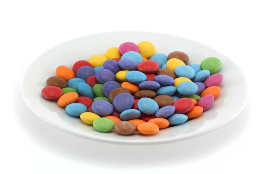 Multi coloured halloween candy sweets on a white plate