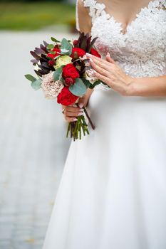 Beautiful wedding bouquet of flowers in the hands of the newlyweds