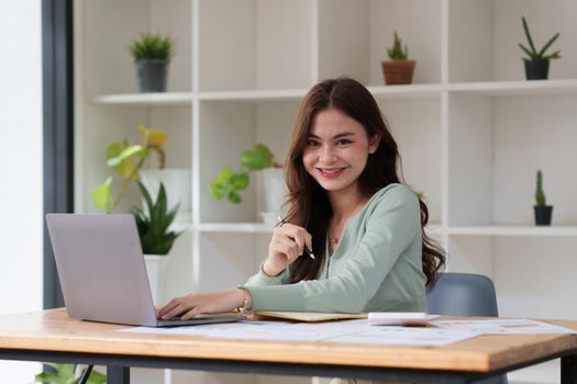 Business Woman analyzes company's financial system and paperwork on desk.