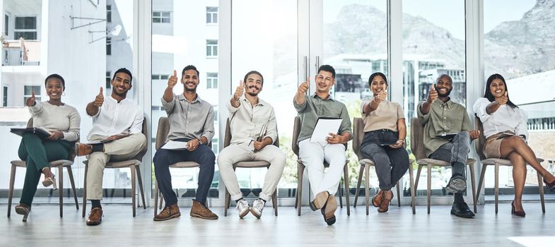 Do you love your job. a group of people showing thumbs up in a modern office