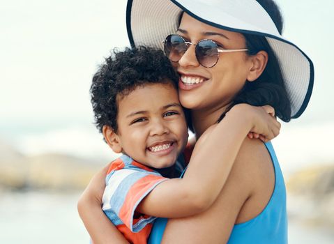 My son is my pride and joy. a mother holding her son at the beach