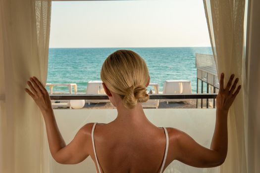 Sea window blonde view room open coast mediterranean vacation travel, from terrace lifestyle for resort from adult girl, female woman. Coastline frame riviera,