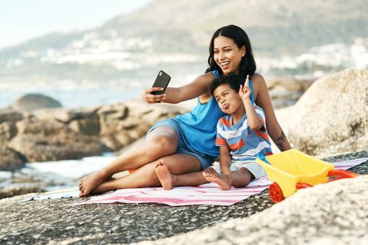 I wish you stay this little forever. a mother and her son taking selfies at the beach