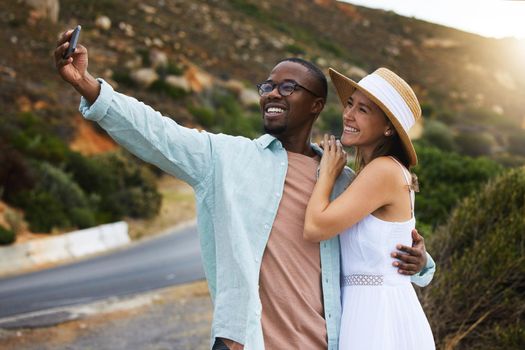 The more we travel the more memories we gain. a happy young couple taking selfies on a road trip