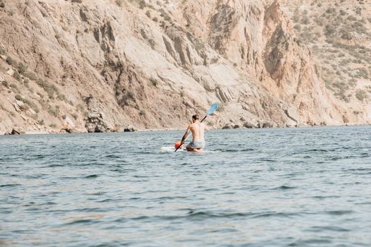 Side view foto of a man swiming and relaxing on the sup board. Sportive man in the sea on the Stand Up Paddle Board SUP. The concept of an active and healthy life in harmony with nature