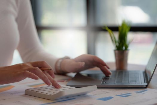 Business woman using calculator to audit the company's financial.