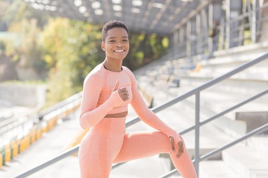 Young female athlete looks at the camera and smiles, stubborn and motivated fitness trenes encourages sports and active lifestyle