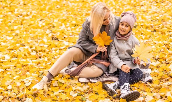 Mother and daughter in autumn yellow park