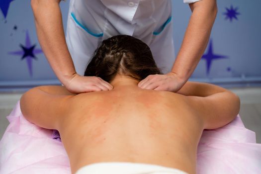 Facial massage. A woman is given a massage in a beauty salon. Close-up