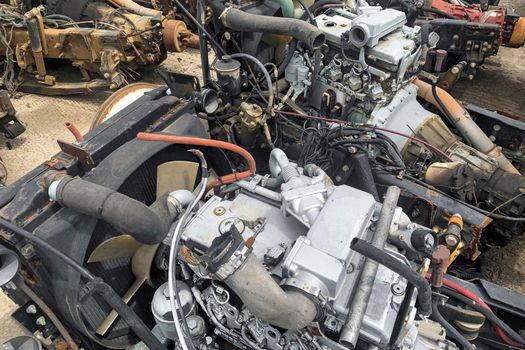 Closeup of detail of broken car engine at the junkyard, motor of crashed automobile in junk yard, spare part for truck lorries.