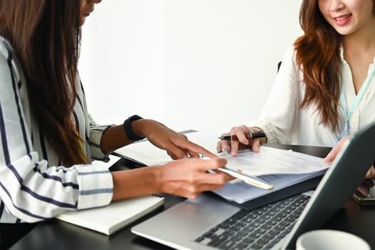 Two business colleagues discussing project planning together at modern workplace.