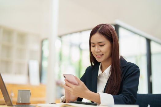 Asian businesswoman using the phone to contact a business partner..