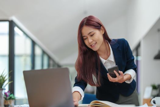 Asian businesswoman using the phone to contact a business partner.