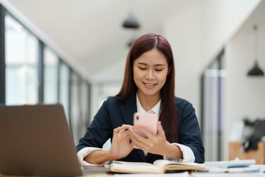 Asian businesswoman using the phone to contact a business partner..