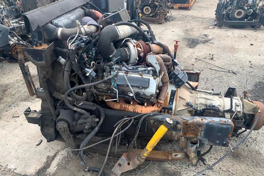Closeup of truck engine for recycling, motor of crashed automobile in junkyard, spare part for truck lorries.
