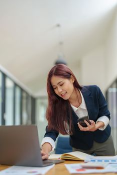 Asian businesswoman using the phone to contact a business partner.