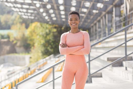 Young female athlete looks at the camera and smiles, stubborn and motivated fitness trenes encourages sports and active lifestyle