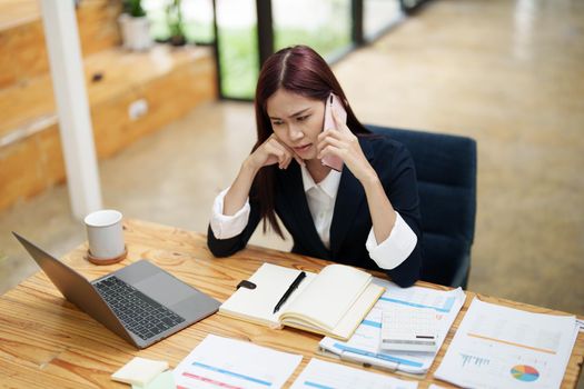 businesswoman showing a serious expression while talking on the phone.