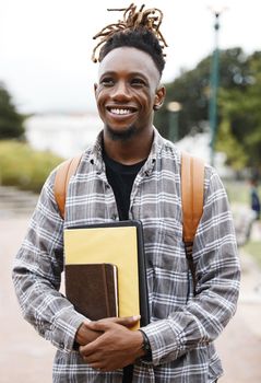 Education is the key to success. a young man holding books on campus