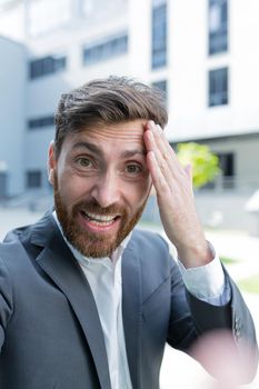 Businessman uses video call for serious conference and quarrels, man yells at employees looking at smartphone camera