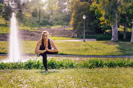 young sports woman doing meditation yoga balancing exercises and relaxing outdoors in the park, modern healthy lifestyle and sport concept
