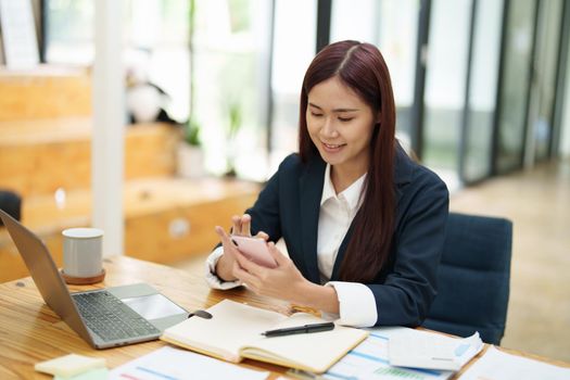 Asian businesswoman using the phone to contact a business partner..