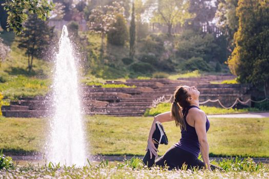 young sports girl doing meditation yoga exercises and relaxing outdoors in the park, modern healthy lifestyle and sport concept