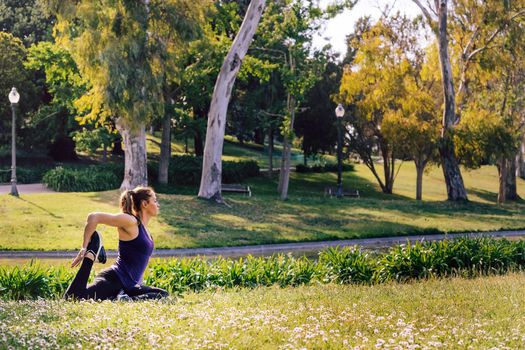 young sports woman doing meditation yoga flexibility exercises and relaxing outdoors in the park, modern healthy lifestyle and sport concept