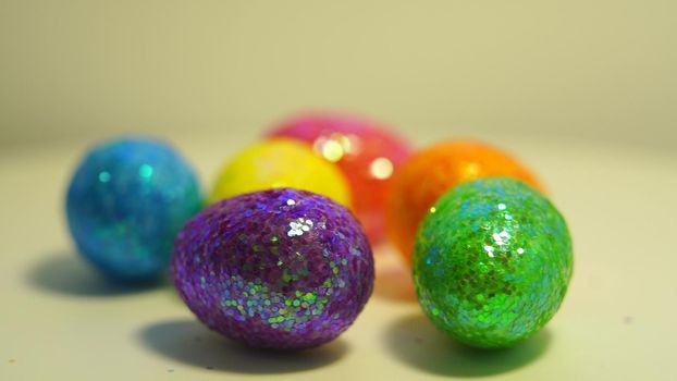 Colorful Easter eggs rotating in rows in a seamless loop on a light background.