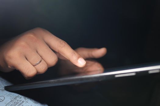 man hand using digital tablet on black background .