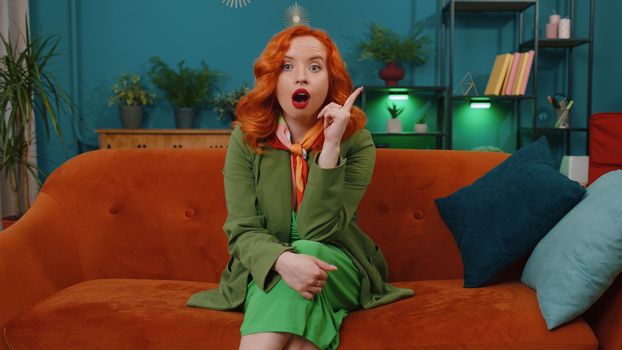 Eureka. Thoughtful clever inspired redhead young woman make gesture raises finger came up with creative plan feels excited with good idea, inspiration motivation. Ginger girl at home in living room