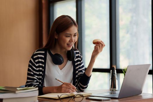 Back to school concept. Young college woman using laptop at library.