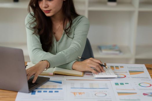 Business Woman analyzes company's financial system and paperwork on desk.