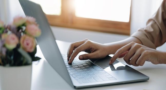 Businesswoman using laptop computer keyboard at the office..