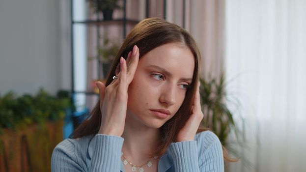 Close-up portrait of tired woman freelancer teacher suffering from tension, migaine headache after e-learning, remote working job study with pupils sitting at home office. Adult girl businesswoman