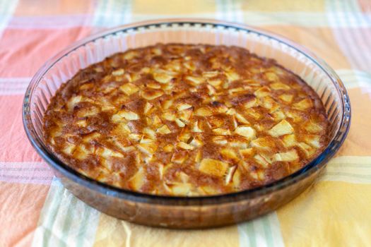 apple pie in a glass mold on a yellow napkin, side view