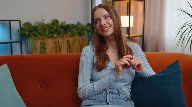 Portrait of happy calm young woman smiling friendly glad expression looking away dreaming resting, relaxation feel satisfied concept good news sitting on sofa at home room. Pretty girl falling in love