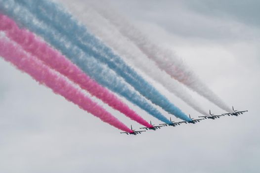 Russian Air Force planes paint the colors of the Russian flag in the sky on St. Petersburg during the celebration of the Day of the Navy. High quality photo