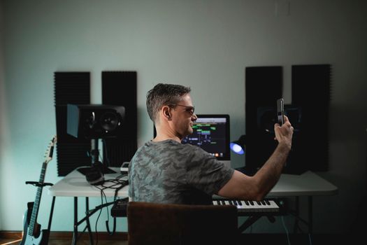 Portrait of a music producer at his home studio taking a selfie to upload it to his social networks to bond with his followers