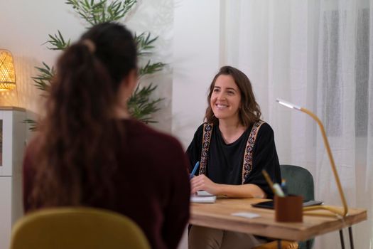 A female therapist in her office talking to a client to determine the best treatment for her health