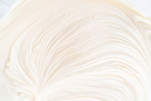 Close up view. Preparing vanilla buttercream frosting for decorating funfettti bundt cake.