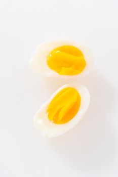 Slicing hard-boiled eggs on a white cutting board.