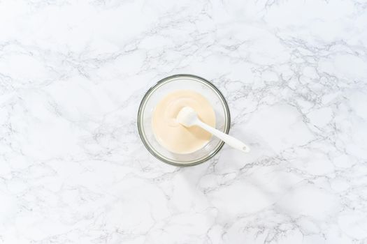 Flat lay. Melting white chocolate chips in a candy melting pot to bake peppermint white chocolate cookies.