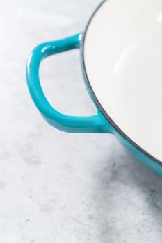 Clean cast iron enameled braiser on the kitchen counter.