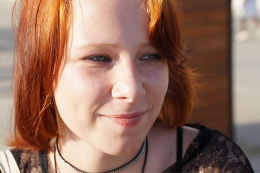 portrait of a smiling red-haired teenage girl close-up