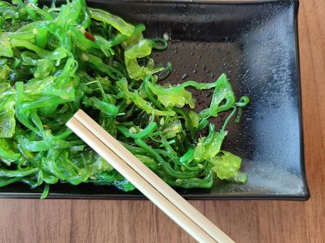 seaweed with sesame seeds and japanese wooden sticks close-up