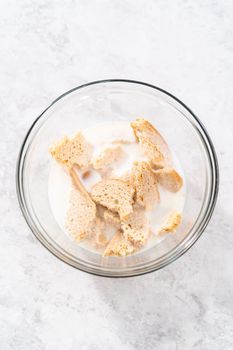 Soaking stale bread in milk to make meatloaf.