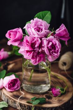 Bouquet of small pink garden roses in vase on table